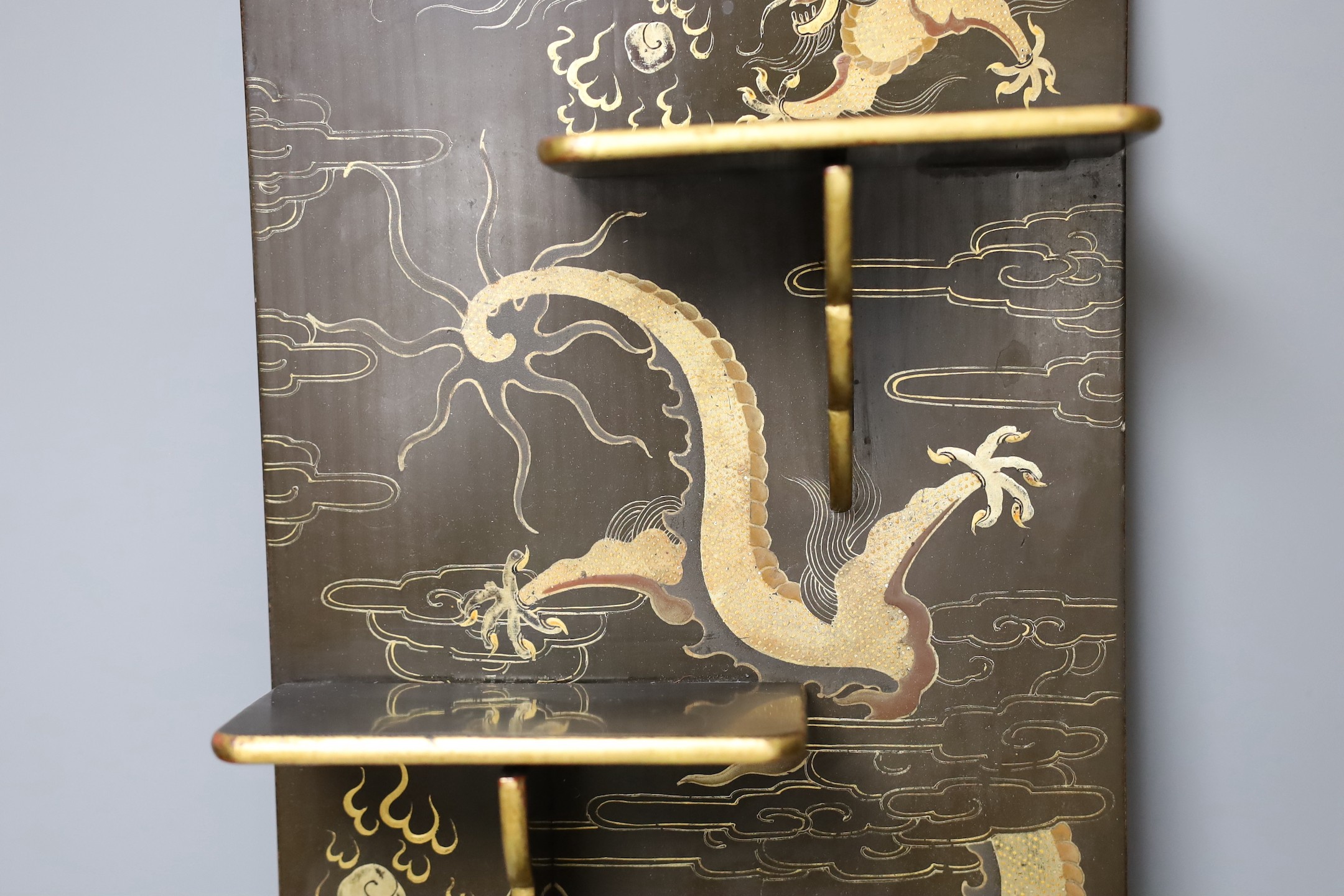 A Chinese lacquer ‘dragon’ wall shelf, 55x25cm